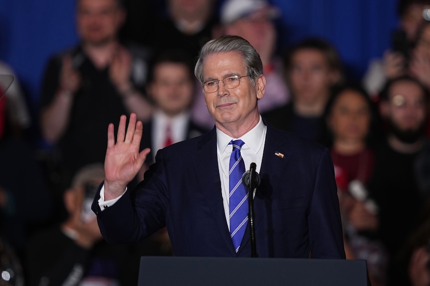 Scott Bessent standing in a black suit and blue tie.