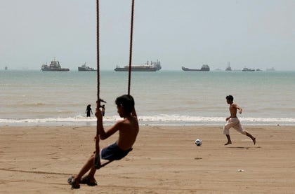 A child plays at the beach, with vessels in the Strait of Hormuz visible near the beach of Bandar Abbas, Iran, May. Credit: Majid Asgaripour/REUTERS A child plays at the beach, with vessels in the Strait of Hormuz visible near the beach of Bandar Abbas, Iran, May.