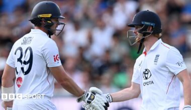 England Test captain Joe Root holding a bat and talking to Rob Key