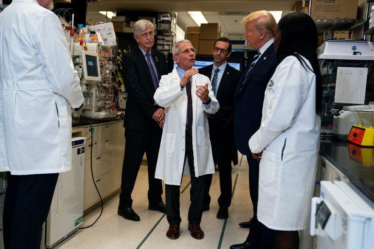 Anthony Fauci, director of the National Institute of Allergy and Infectious Diseases, talks with President Donald Trump in March 2020