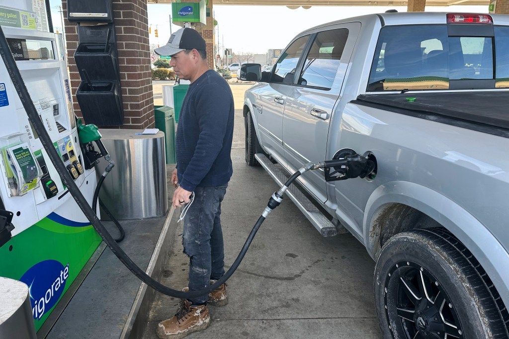 Josue Hernandez, 35, pumps gas into his work pickup truck at a gas station in Southfield, Mich., Monday, March 9, 2026. (AP Photo/Corey Williams)
