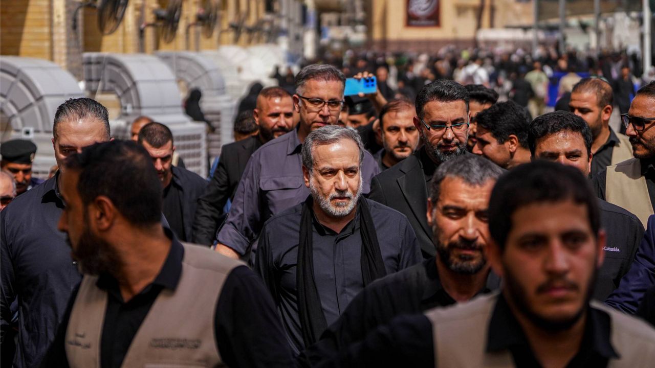 Iran's Foreign Minister Abbas Araghchi, center, is surrounded by security personnel as he walks in Najaf, Iraq, during Arbaeen commemorations, Monday, Aug. 3, 2026. (AP Photo/Anmar Khalil)