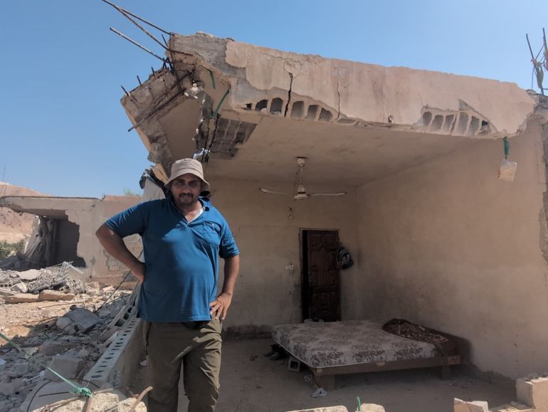 Ali Kaabneh in front of his partially destroyed home he still lives in [Courtesy of Unarmed Civilian Protection in Palestine]