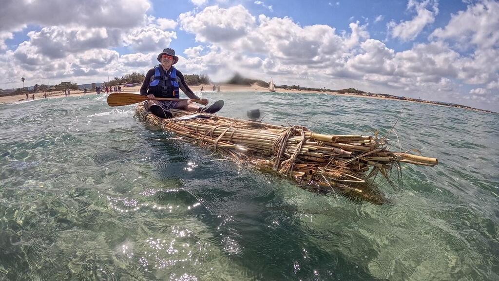 Shay Niv paddles the reed boat (Photo: Amir Yorman) שי ניב חותר בסירת הקנים שנבנתה כחלק ממחקרו הניסויי