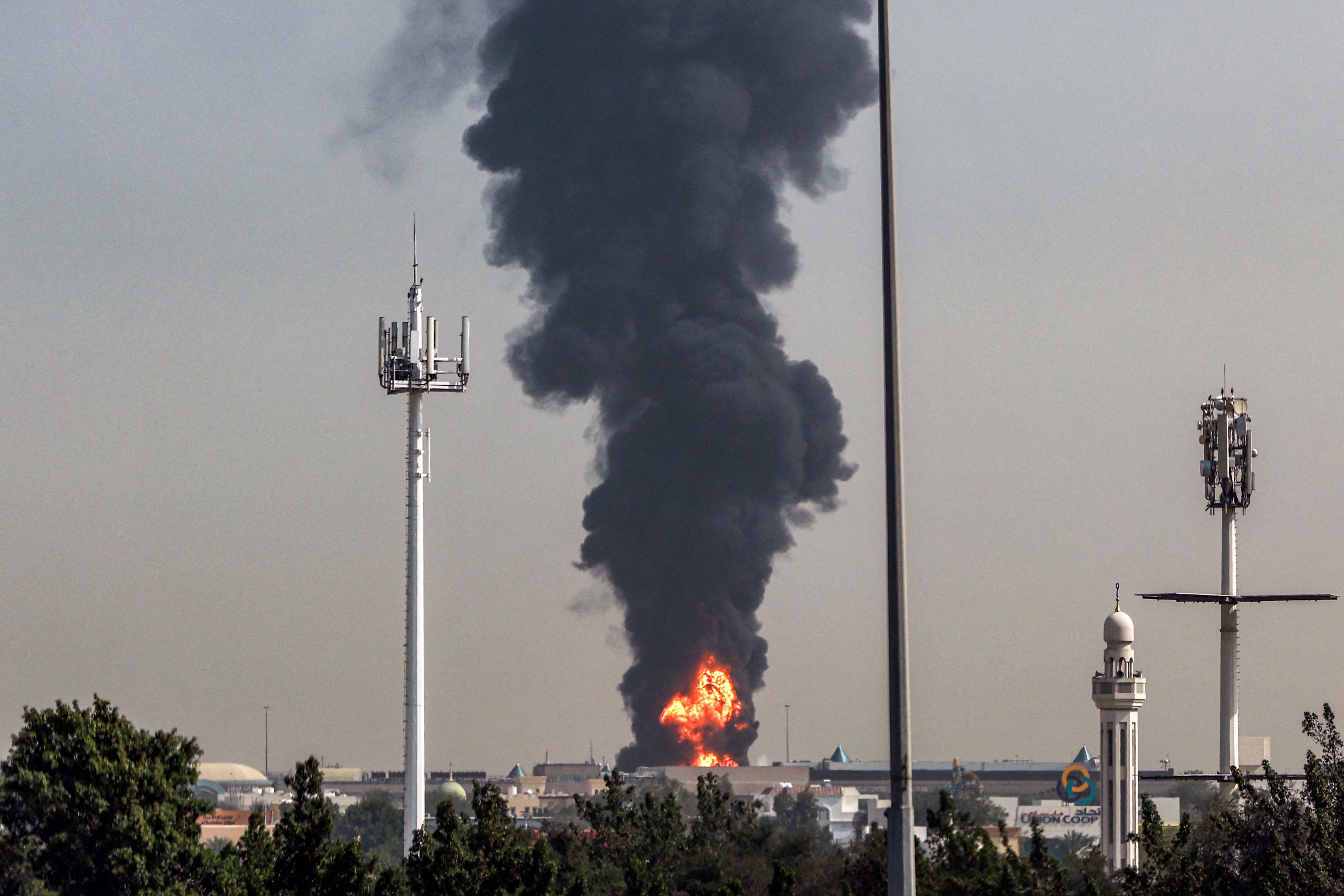 A smoke plume rises from an ongoing fire near Dubai International Airport in Dubai on March 16