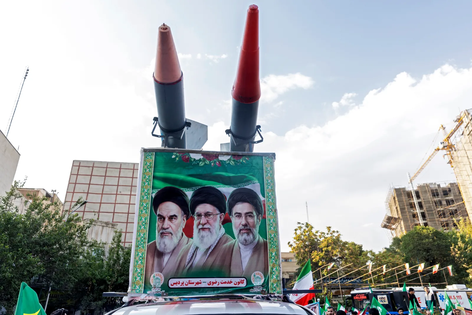A car with replicas of missiles and an image of new Iranian Supreme Leader Ayatollah Mojtaba Khamenei, right, and late leaders Aytollah Ali Khamenei, center, and Ayatollah Ruhollah Khomeini, left, appears at a gathering to commemorate the death of Imam Reza on August 12, 2026, in Tehran, Iran.