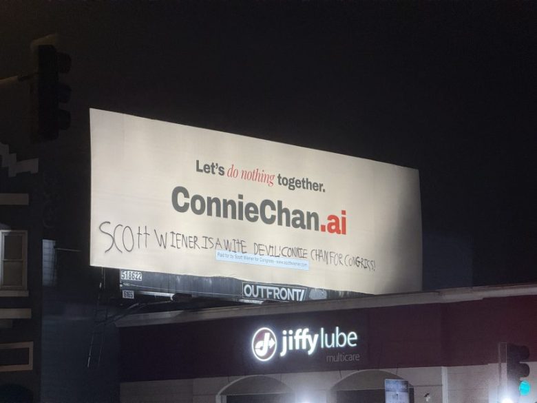 A billboard for ConnieChan.ai with the slogan “Let’s do nothing together” has graffiti that reads, “SCOTT WIENER IS A WHITE DEVIL CONNIE CHAN FOR CONGRESS” above a Jiffy Lube.