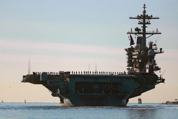 Sailors and Marines line the deck of aircraft carrier USS Abraham Lincoln (CVN-72) as it deploys from San Diego, Jan. 3, 2021. (K.C. Alfred/The San Diego Union-Tribune via AP, File)