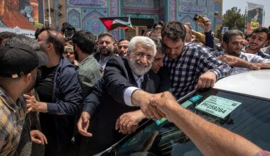 Candidate for Iran's presidential election Saeed Jalili, a hard-line former nuclear negotiator, shakes hands with a supporter after casting his vote for the presidential runoff election in Qarchak, near Tehran, Iran, on July 5, 2024.
