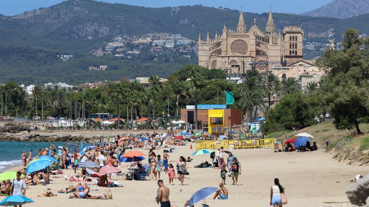 Sunbathers at a beach during a heatwave in Palma, Spain, on Sunday, July 27, 2025.??Tourism??in??Spain, Europe's second largest holiday destination, will grow less than previously expected as economic and geopolitical uncertainties weigh on appetite for travel.??Photographer: Andrey Rudakov/Bloomberg via Getty Images