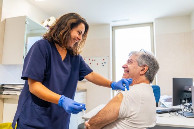 A nurse gives a flu vaccine to a patient