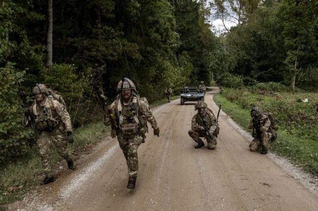 Soldiers on maneuvers with a Viking, an Iveco Defence Vehicles unmanned ground vehicle (AGV), during NATO-linked military exercises with British, Latvian, Canadian and Italian forces, in Latvia, on Sunday, Oct. 5, 2025. In the wilds of Latvia, the British military is trying out new battlefield technology and how to best integrate 'the technician and the tactician' in weapons development. Photographer: Damian Lemanski/Bloomberg via Getty Images