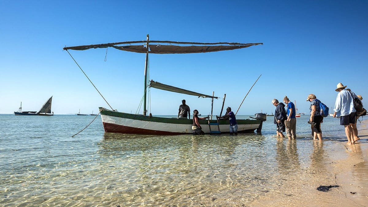 Tourists getting on boat on beach in Mozambique