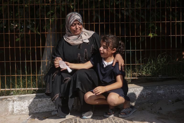 A Palestinian woman and a child mourn during the funeral of Huthaifa Kawari, who, according to health officials, was killed in an Israeli strike, at Nasser Hospital in Khan Younis, southern Gaza Strip, on August 13, 2026 [AFP]
