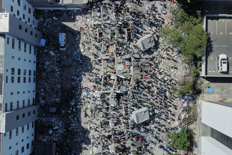 Residents and rescue workers search through the rubble after an earthquake struck Cali, Colombia, Monday, Aug. 10, 2026. (AP Photo/Santiago Saldarriaga)