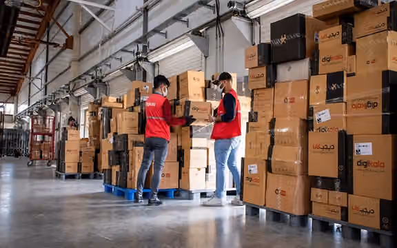 Workers handle packages at a Digikala warehouse in Iran.