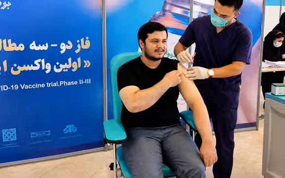 Hojjat Niki-Maleki receives a COVID-19 vaccine during a clinical trial in Iran.