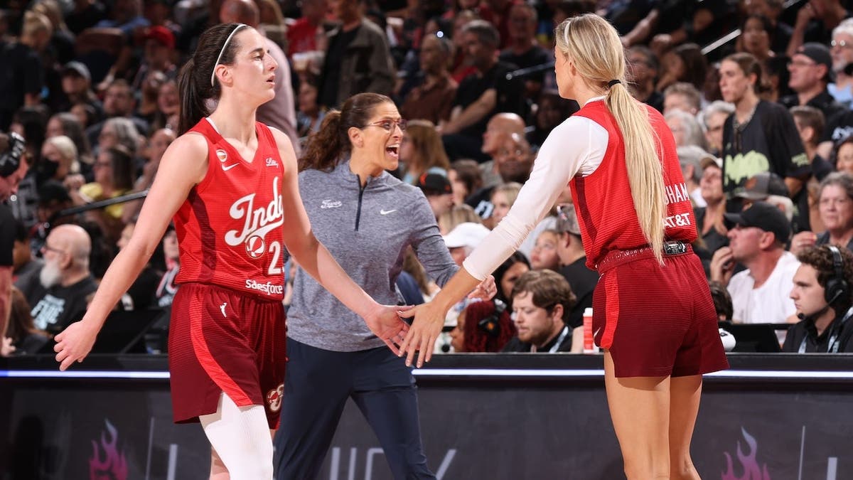 Caitlin Clark #22 and Sophie Cunningham #8 high five during an Indiana Fever game.