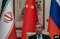 Chinese Foreign Minister Wang Yi speaks during a meeting with his Russian and Iranian counterparts regarding the Iranian nuclear issue, in Beijing in March 2025.