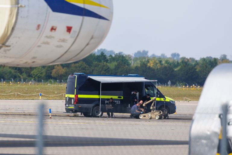 LEIPZIG, GERMANY - AUGUST 5: Police investigators work on the tarmac with a robot that is capable, amongst other things, of defusing explosives, near to Ukrainian Antonov cargo plane at Leipzig/Halle Airport on August 5, 2026 near Leipzig, Germany. Airport workers reportedly discovered a drone yesterday on the tarmac near an Antonov at the airport that was equipped with an explosives detonator and an unidentified substance. Additionally, a DHL cargo plane that took off from the airport late last night collided with a small object, causing minor damage. (Photo by Jens Schlueter/Getty Images)