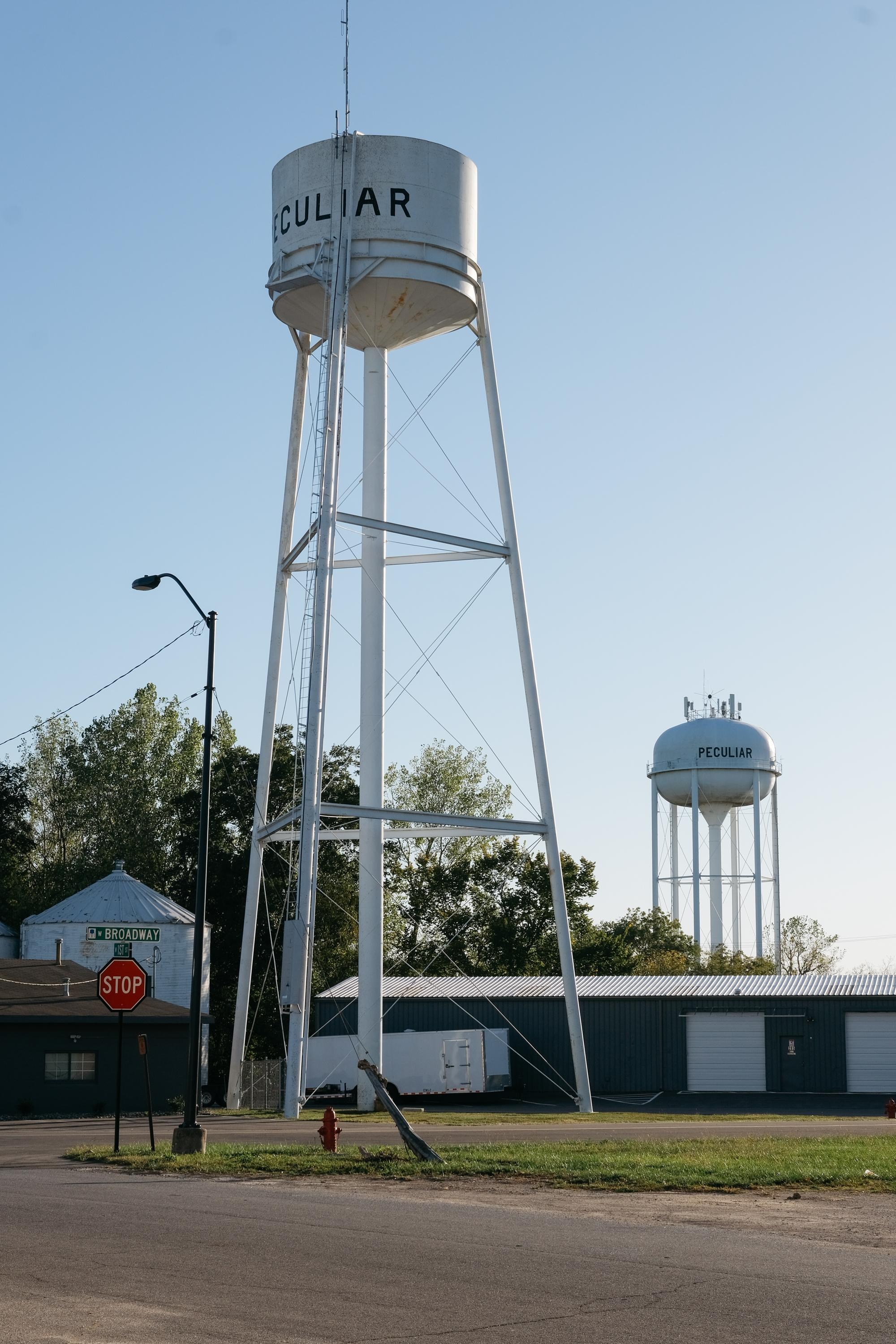 Two water towers on a rural American street.