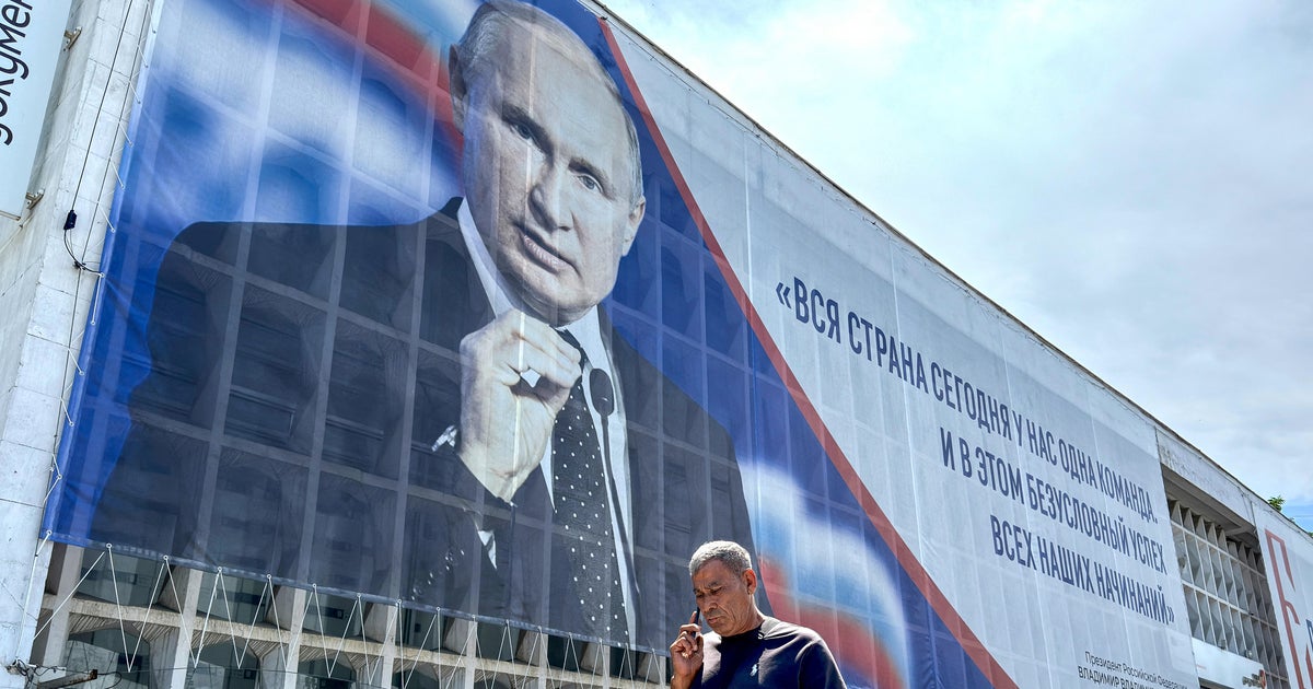 A man walks past a billboard displaying a portrait of Russia's President Vladimir Putin in Sevastopol, on the Russian-annexed peninsula of Crimea, on July 23, 2026.