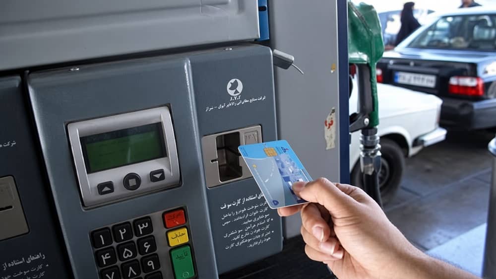 A driver inserts a smart fuel rationing card into the reader at a gas station in Shiraz, southern Iran