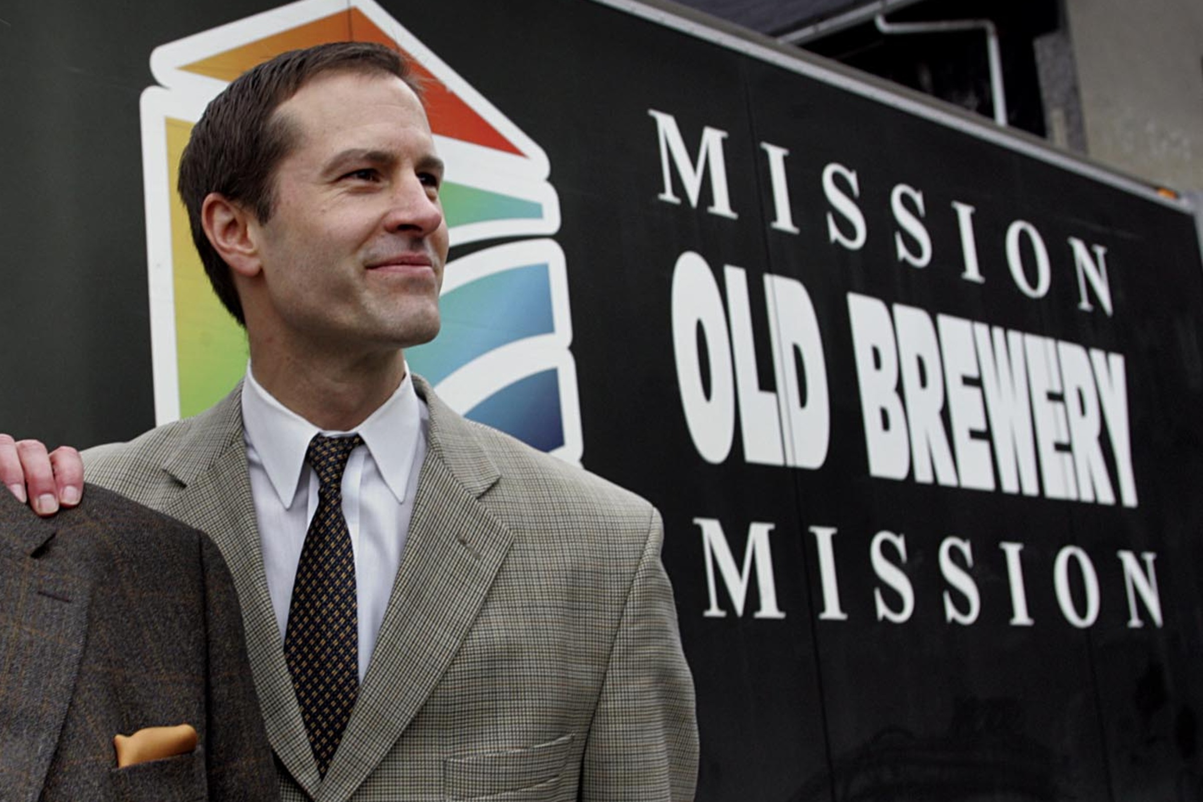 James Hughes next to a sign for the Old Brewery Mission.