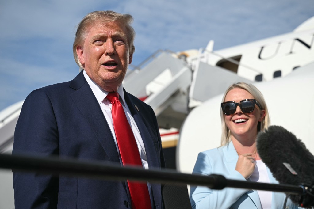 Donald Trump speaking to reporters, flanked by Karoline Leavitt.