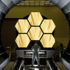 Ernie Wright stands near the James Webb Space Telescope mirrors as they sit just outside the testing chamber in the x-ray calibration facility at MSFC.