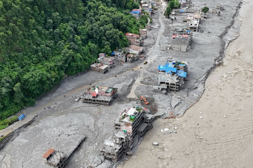 A torrent of muddy water surging past houses and through the Trishuli River in the aftermath of flash floods in Nepal's Nuwakot district, on September 1.