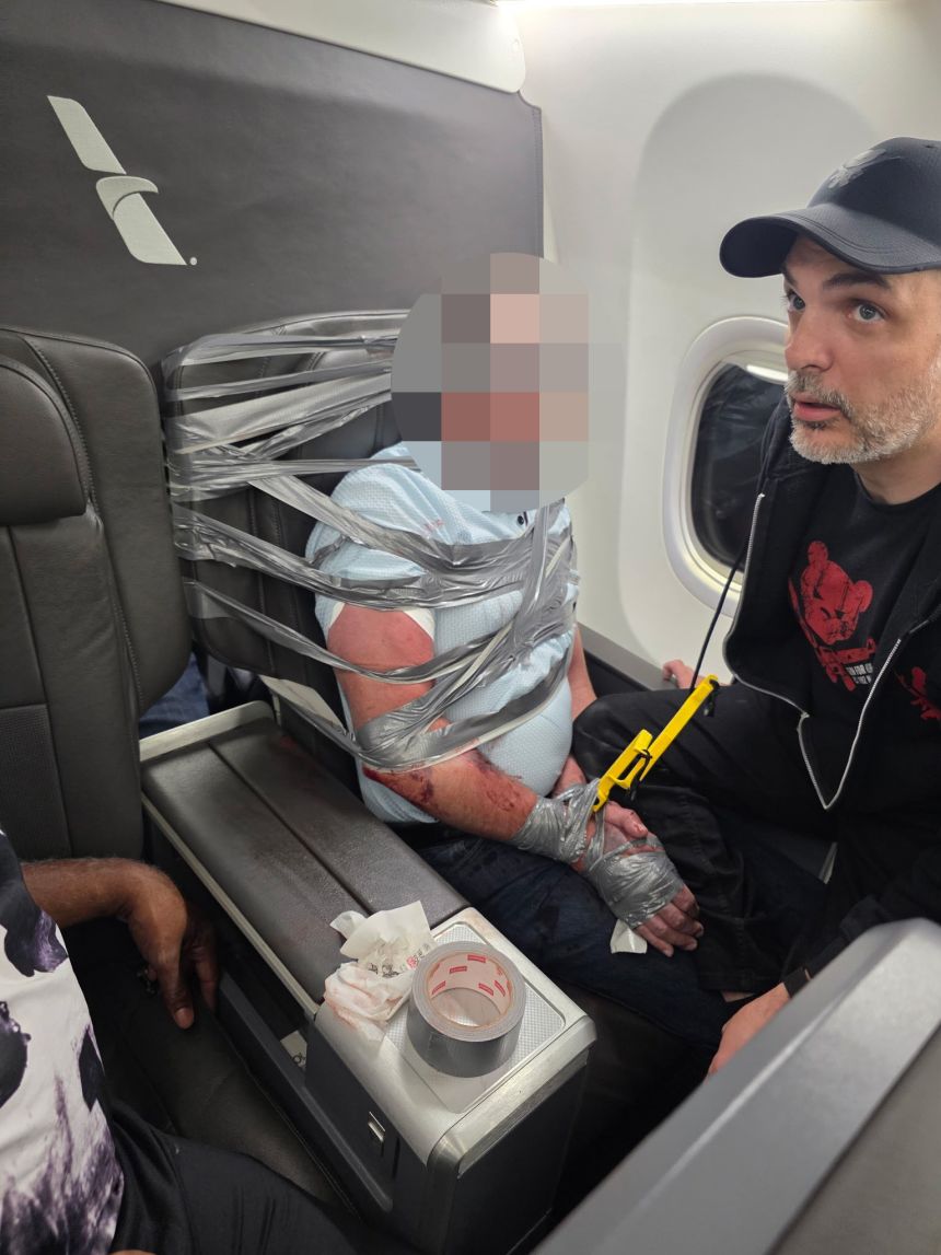 Richard Olenick stands next to the unruly passenger on the American Airlines flight.