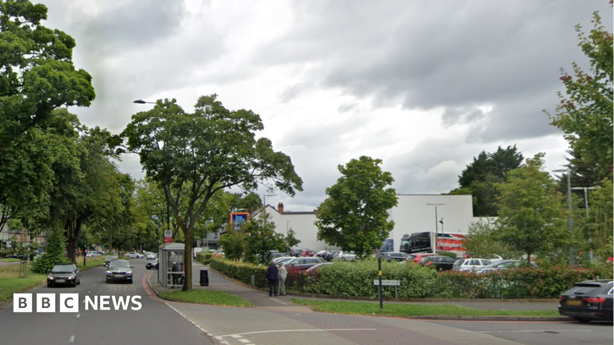 A busy road next to an Aldi superstore, with a road on the right hand side.