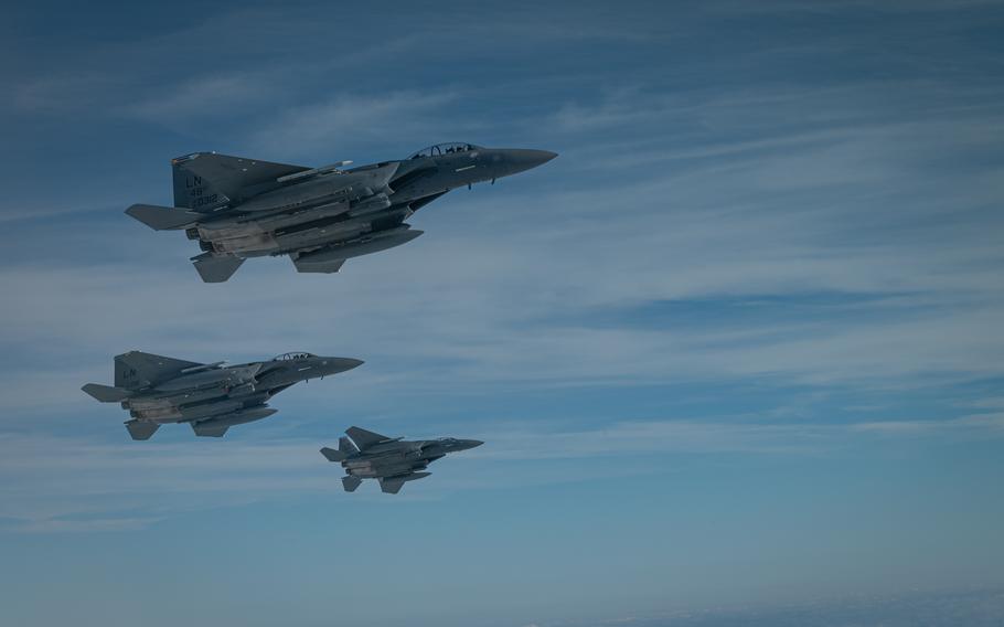 Three fighter jets fly in formation near a refueling tanker.