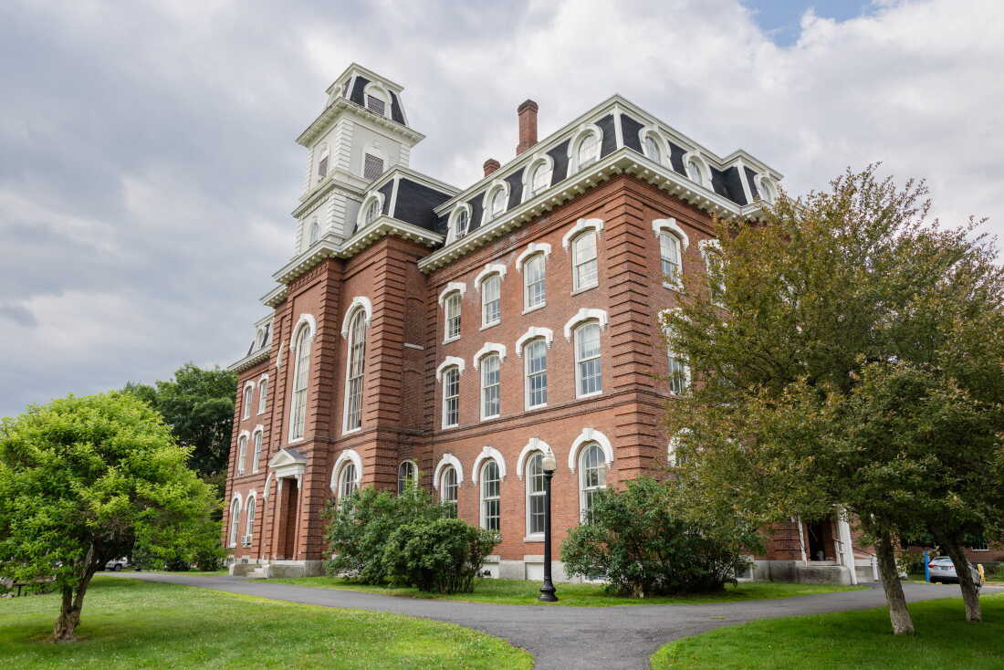 This photo shows a multistory, older-style brick building with a mansard roof on a former college campus in Montpelier, Vermont.