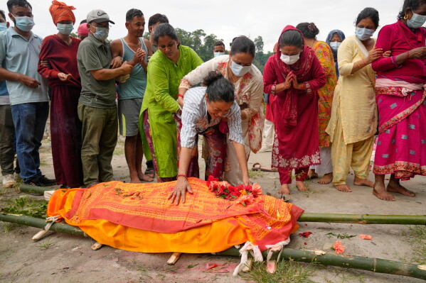 Muna Khadka, center, mother of Aayush Khada, who was killed in flash floods, breaks down during her son's cremation in Chitwan, Nepal, Monday, Aug. 31, 2026. (AP Photo/Dar Yasin)