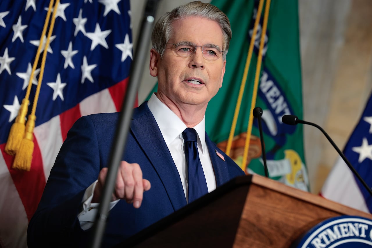 A man in a suit speaks at a podium.