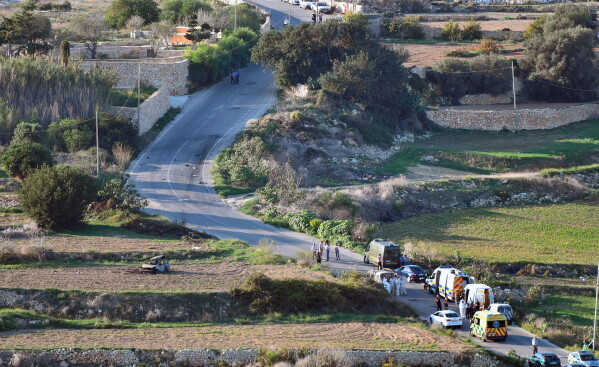 An ambulance and police vehicles are parked along the road where a car bomb exploded killing investigative journalist Daphne Caruana Galizia, in the town of Mosta, Malta, Oct. 16, 2017. (AP Photo/Rene Rossignaud, File)