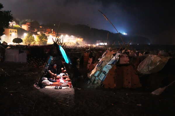 Migrants sit inside their tents at El Trampolín beach in the Spanish exclave of Ceuta, Wednesday, Sept. 2, 2026. (AP Photo/Francis González)