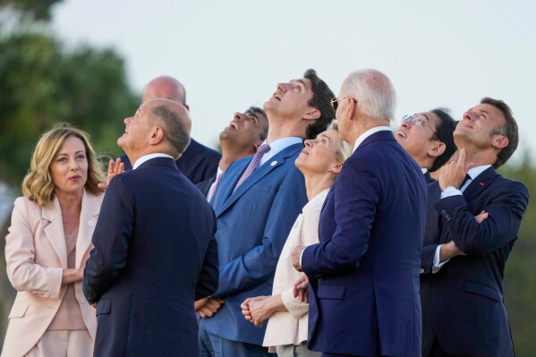 FILE -- From right, French President Emmanuel Macron, Japan's Prime Minister Fumio Kishida, U.S. President Joe Biden, European Commission President Ursula von der Leyen, Canada's Prime Minister Justin Trudeau, Britain's Prime Minister Rishi Sunak, European Council President Charles Michel, German Chancellor Olaf Scholz and Italian Prime Minister Giorgia Meloni watch a skydiving demo during the G7 world leaders summit at Borgo Egnazia, Italy, Thursday, June 13, 2024. (AP Photo/Luca Bruno, File)