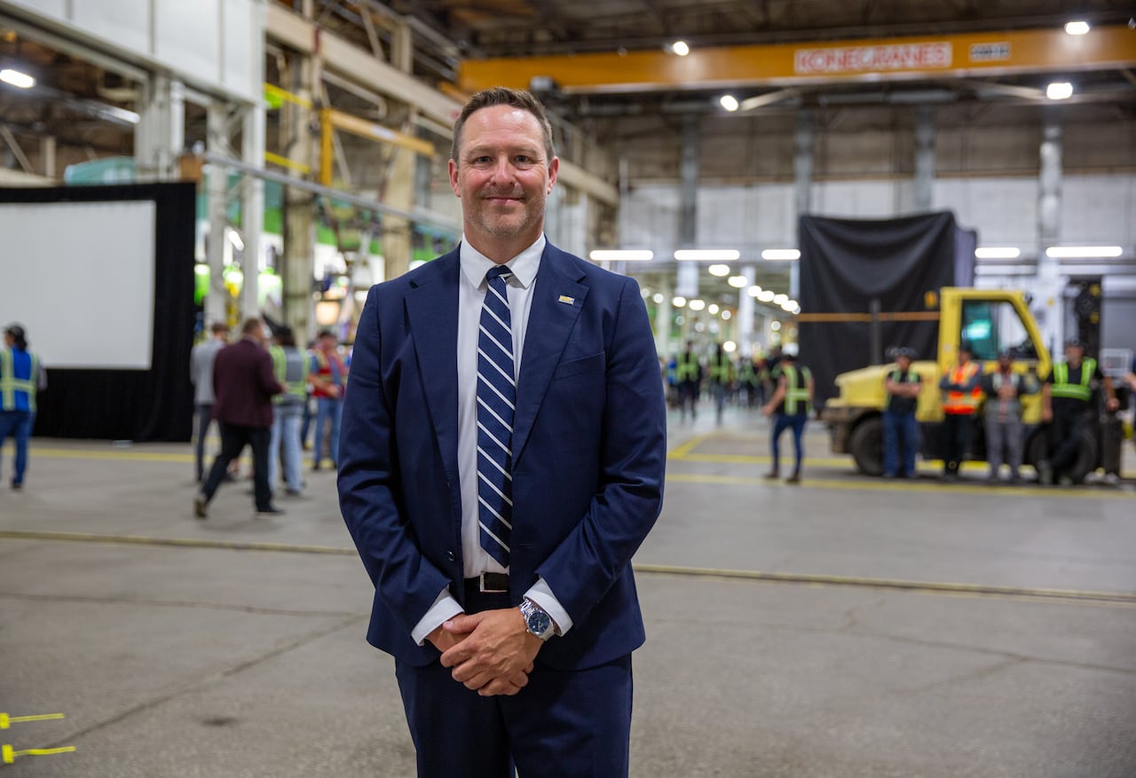 A person wearing a suit and tie is seen in a plant setting.