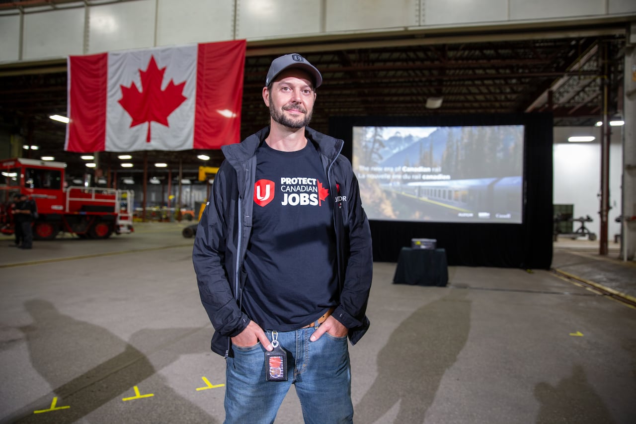 A person is seen standing inside a plant in front of a Canadian flag.
