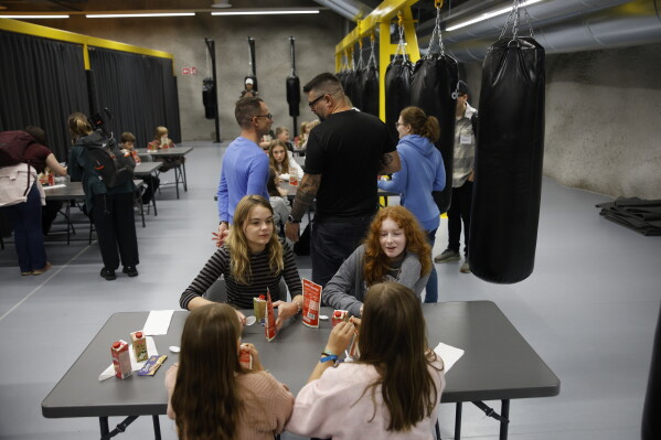 Attendees are eating ready-to-eat meals during the civil defense exercise Shelter 2026 in Kuopio, Finland, Wednesday, Sept. 2, 2026. The exercise is testing how a large number of people can be protected in different types of disruption and during emergency conditions. (Matias Honkamaa/Lehtikuva via AP)