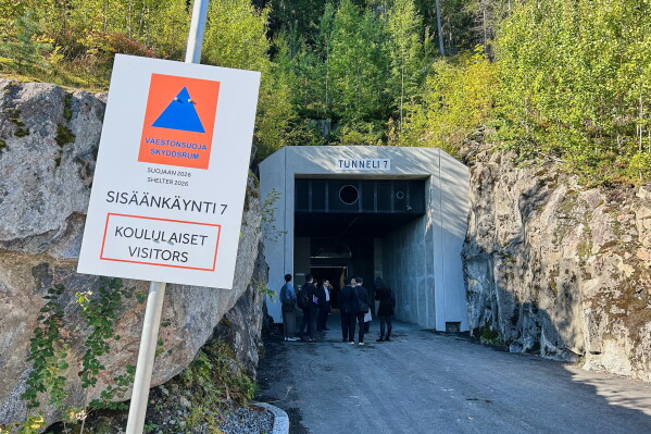 People stand at an entrance of a shelter designed to withstand chemical, nuclear and biological attacks during at civil defense exercise in Kuopio, Finland, Wednesday, Sept. 2, 2026. (AP Photo/Emma Burrows)