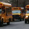 In this photo, three yellow school buses idle in a street in Manhattan's East Village on January 15, 2013.