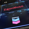 The logos for ExxonMobil and Chevron appear on display screens on the floor of the New York Stock Exchange during morning trading on July 24.