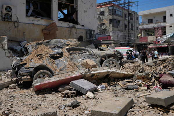 A car lies amidst debris following an Israeli airstrike in the southern port city of Tyre, Friday, June 12, 2026. (AP Photo/Mohammed Zaatari)