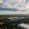 This photo taken from high above shows a Meta data center in Ashburn, Virginia, in 2025. It is a large, long light-colored building with few windows, and it's nestled among trees and a few other buildings with a similar shape.