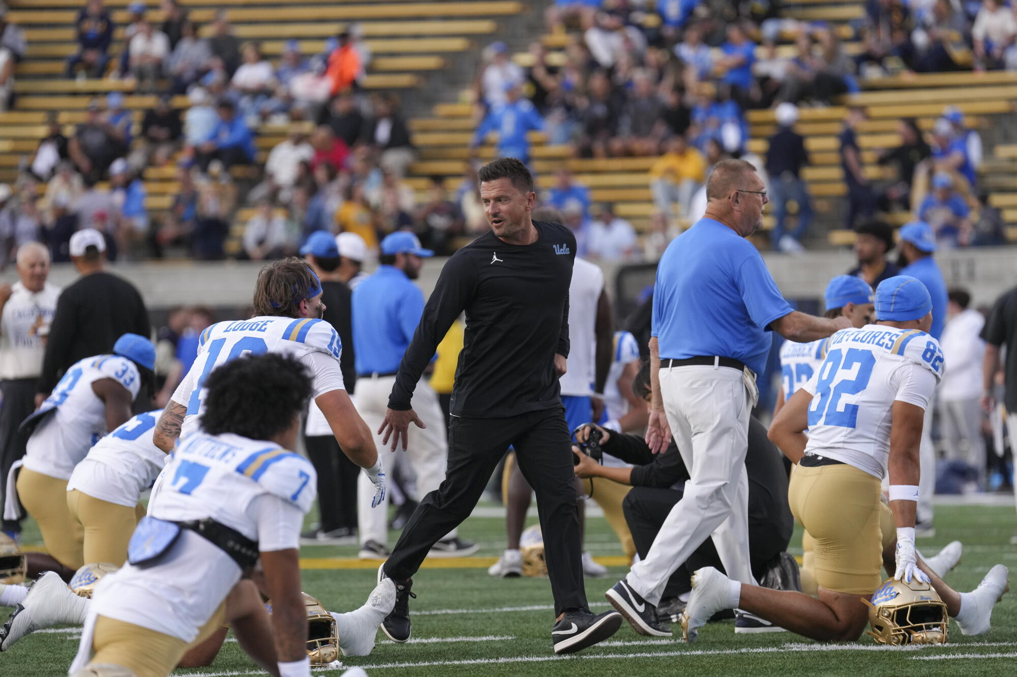 UCLA coach Bob Chesney speaks with his players during pregame stretches on Saturday.