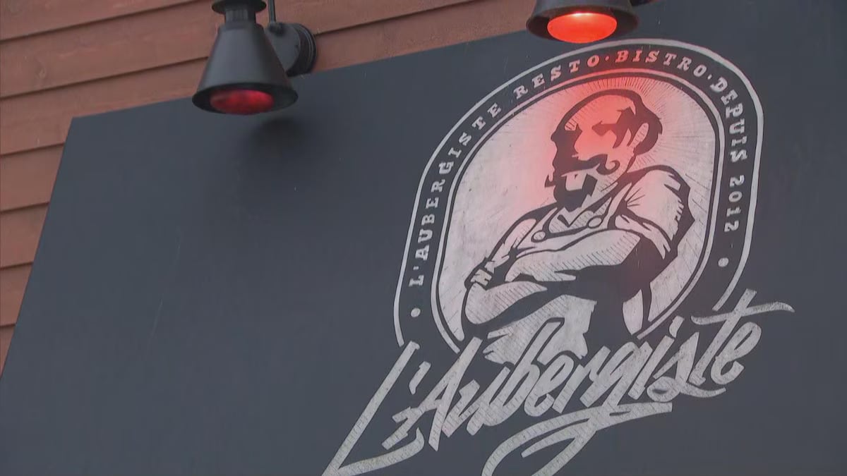 An image of a restaurant sign with a chef crossing his arms.